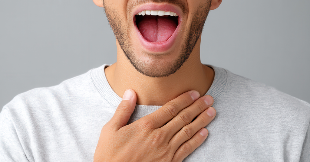 Man with mouth open, holding throat