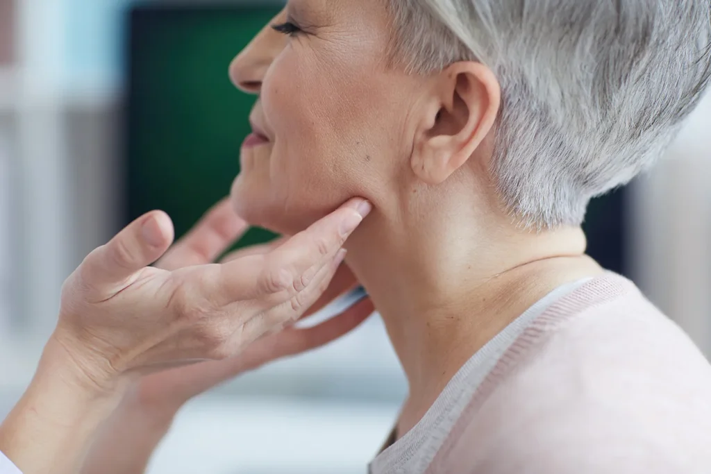 ENT specialist examining a patient’s neck and jaw during a head and neck evaluation at Minnesota ENT.