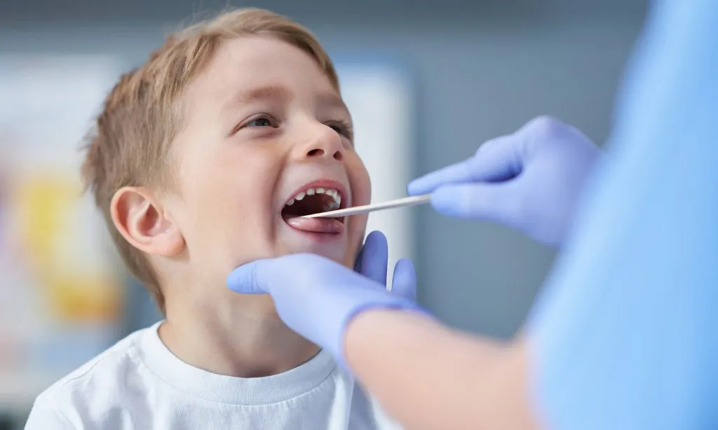Young child having their throat examined by a healthcare provider at Minnesota ENT clinic.